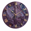 Elegant purple resin wall clock featuring a rich swirling violet design, gold veining, raised Roman numeral markers, and refined gold clock hands, displayed on a decorative stand in a luxurious interior setting