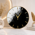 Elegant black-and-white minimalist resin wall clock with gold rim, hands, and markers in a luxury modern setting.