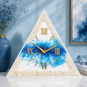 Blue and white triangular resin wall clock with gold Roman numerals and crystal detailing.